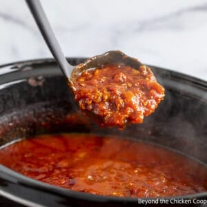 A ladle filled with crock pot spaghetti sauce.