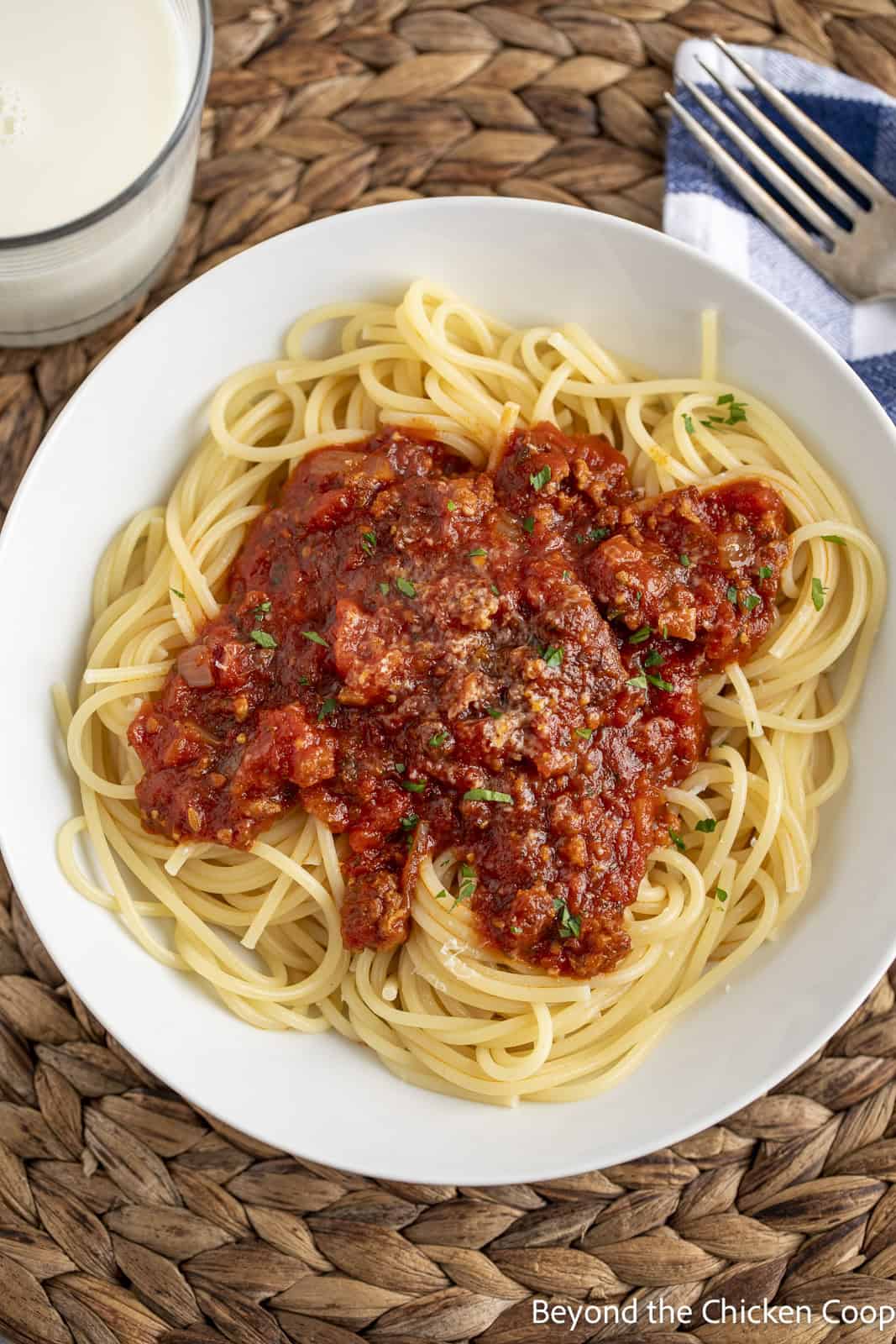 Spaghetti sauce with sausage on a plate of noodles. 