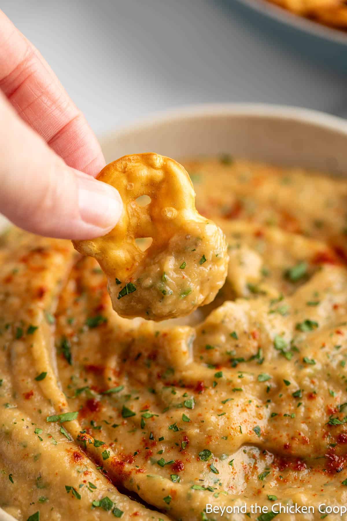A pretzel chip with a scoop of eggplant dip. 
