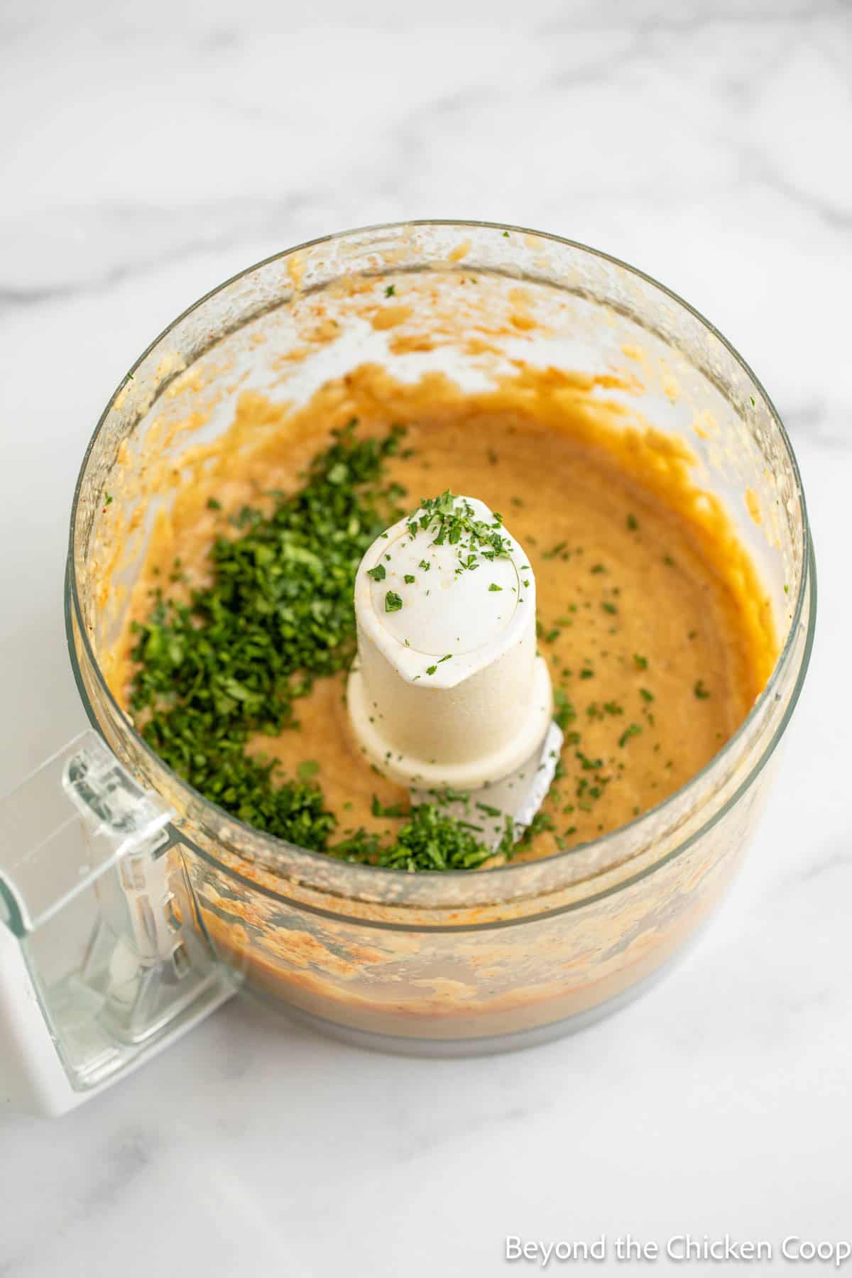 Eggplant dip in a food processor with fresh parsley. 