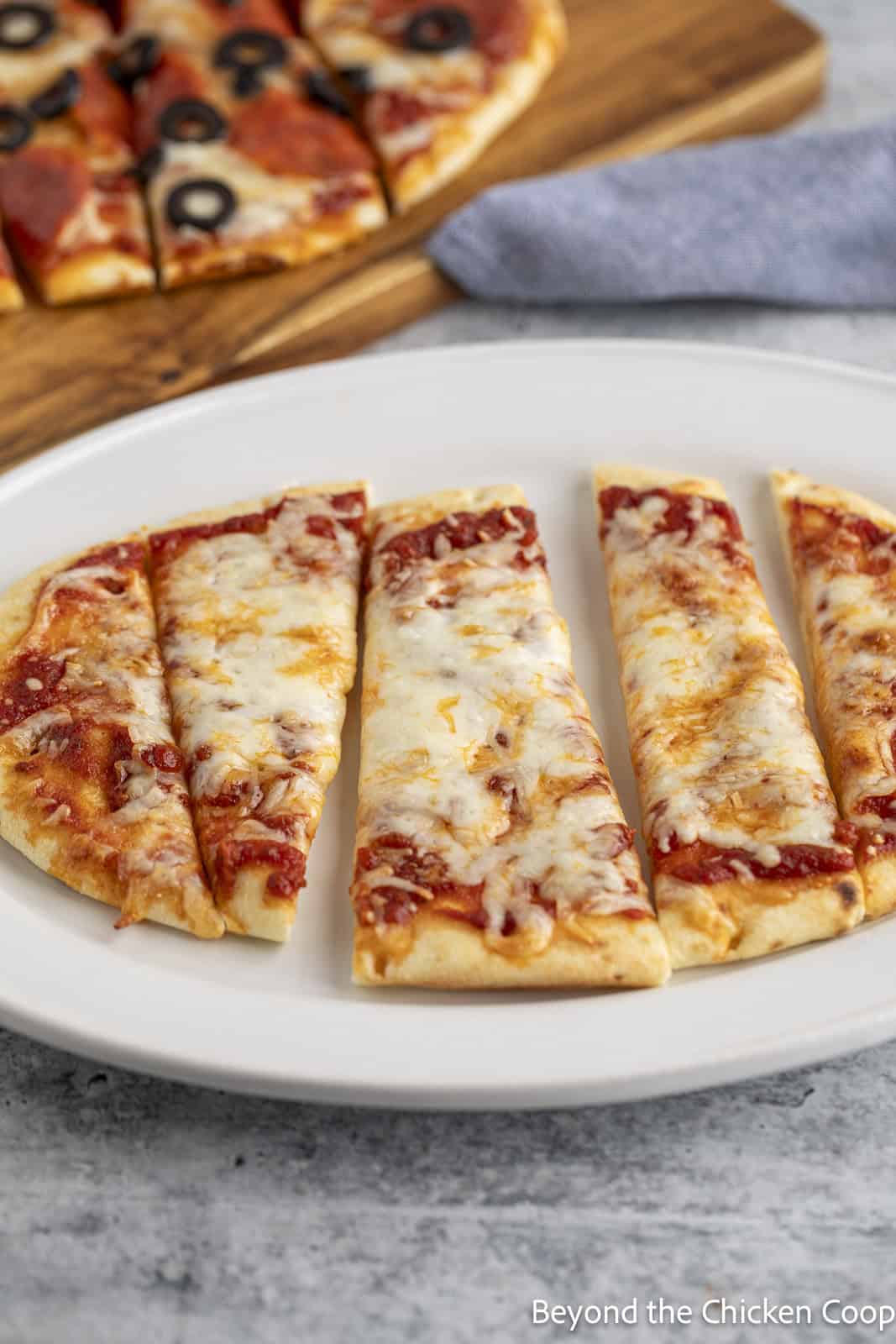 Sliced cheese pizza on a white platter. 