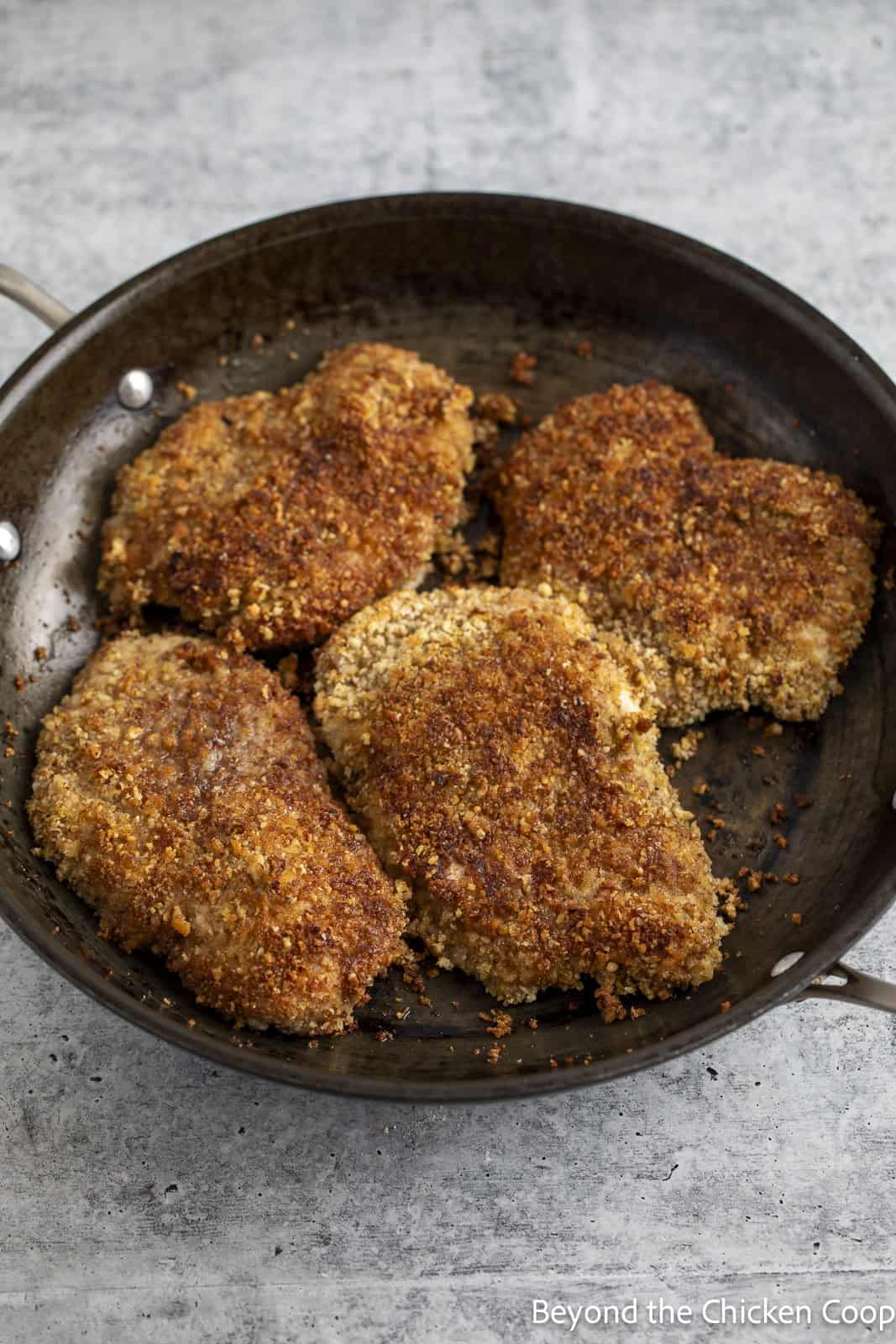 Cooked chicken breasts in a skillet. 