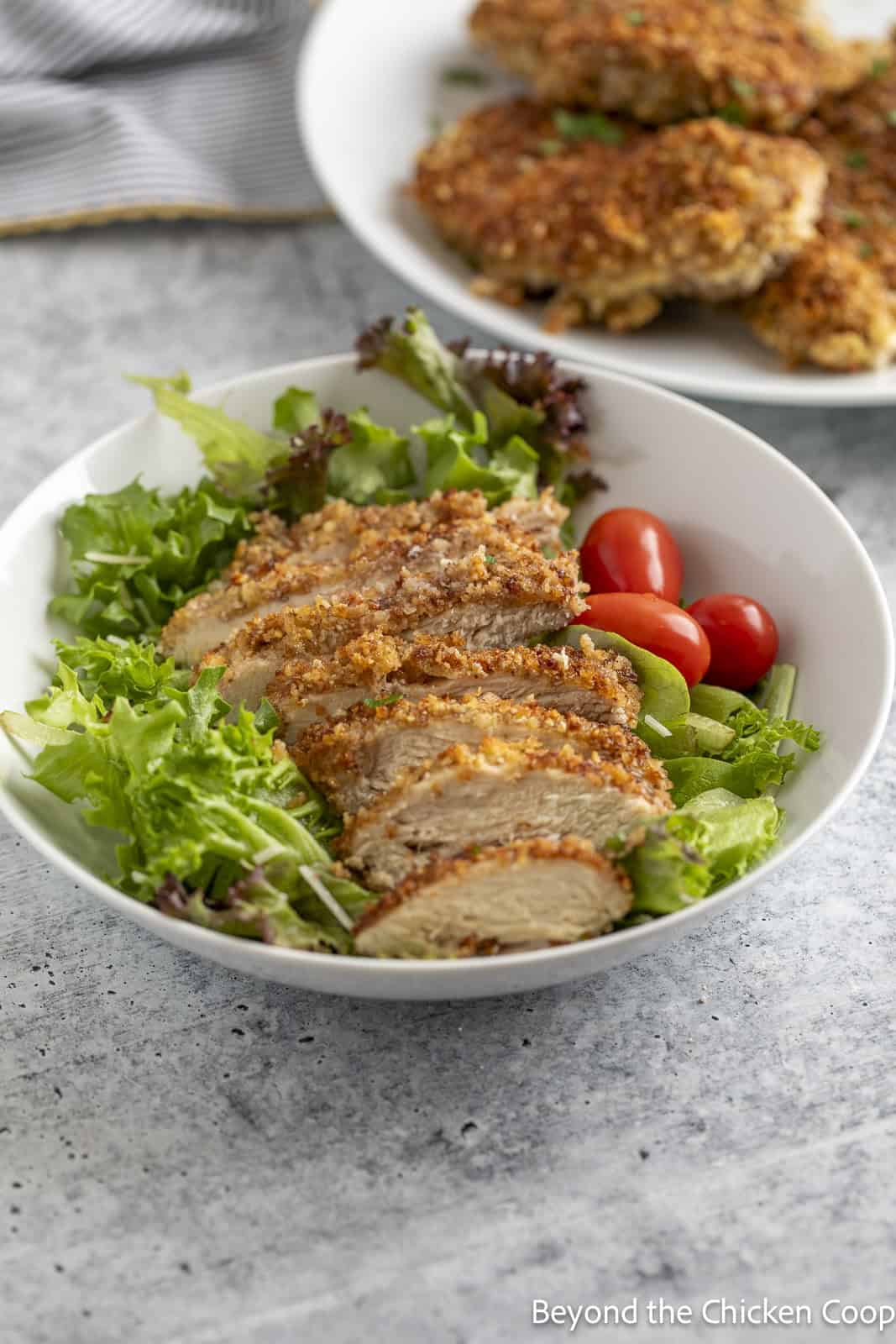 Sliced chicken cutlet on a salad. 