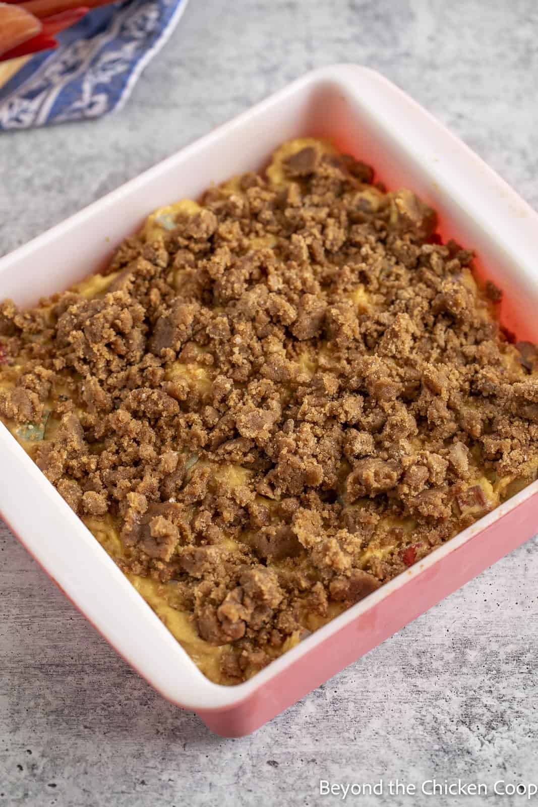An unbaked coffee cake in a glass baking dish. 