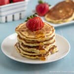 Pancakes with strawberries and syrup.