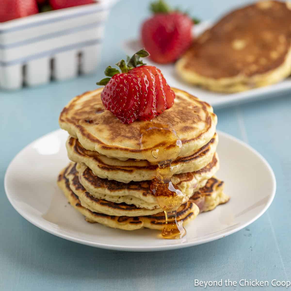 Pancakes with strawberries and syrup.