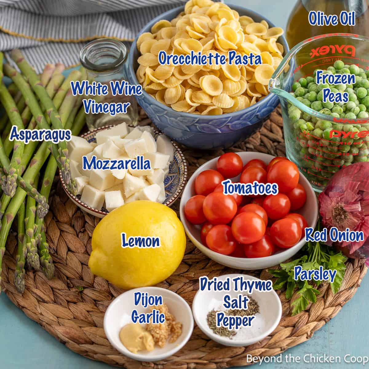 Small bowls filled with tomatoes, peas, pasta, garlic and seasonings. 