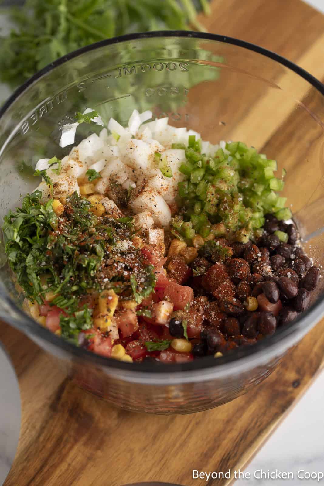Making beans and corn salsa in a glass bowl. 