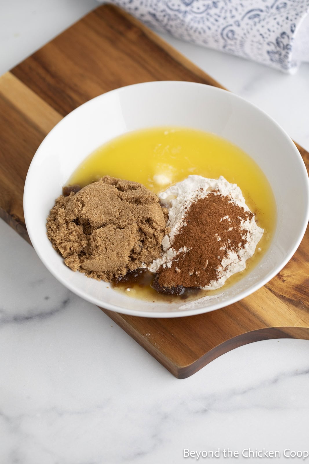 Melted butter, brown sugar, and cinnamon in a white bowl. 