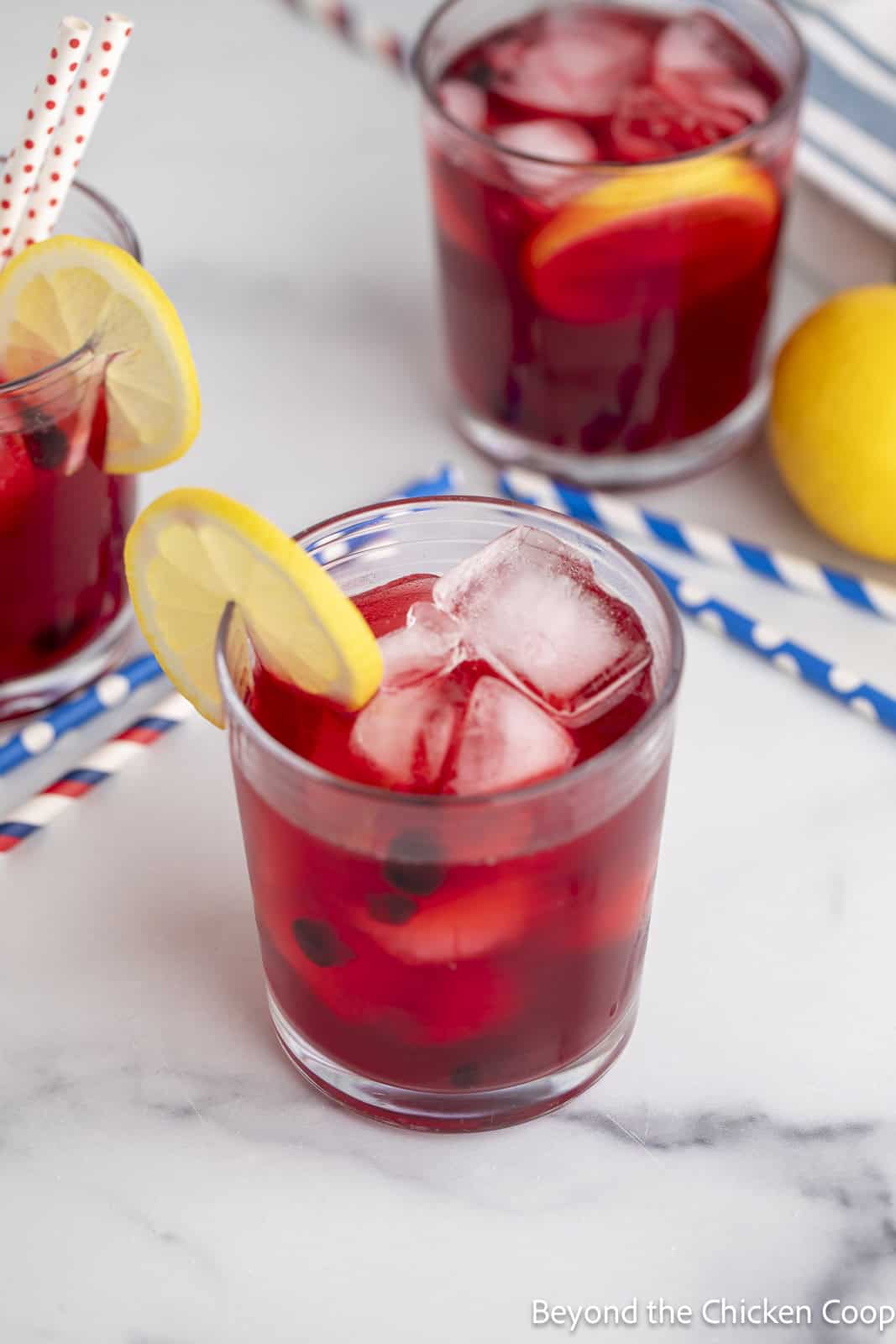 Huckleberry lemonade in a glass filled with ice and a lemon slice. 