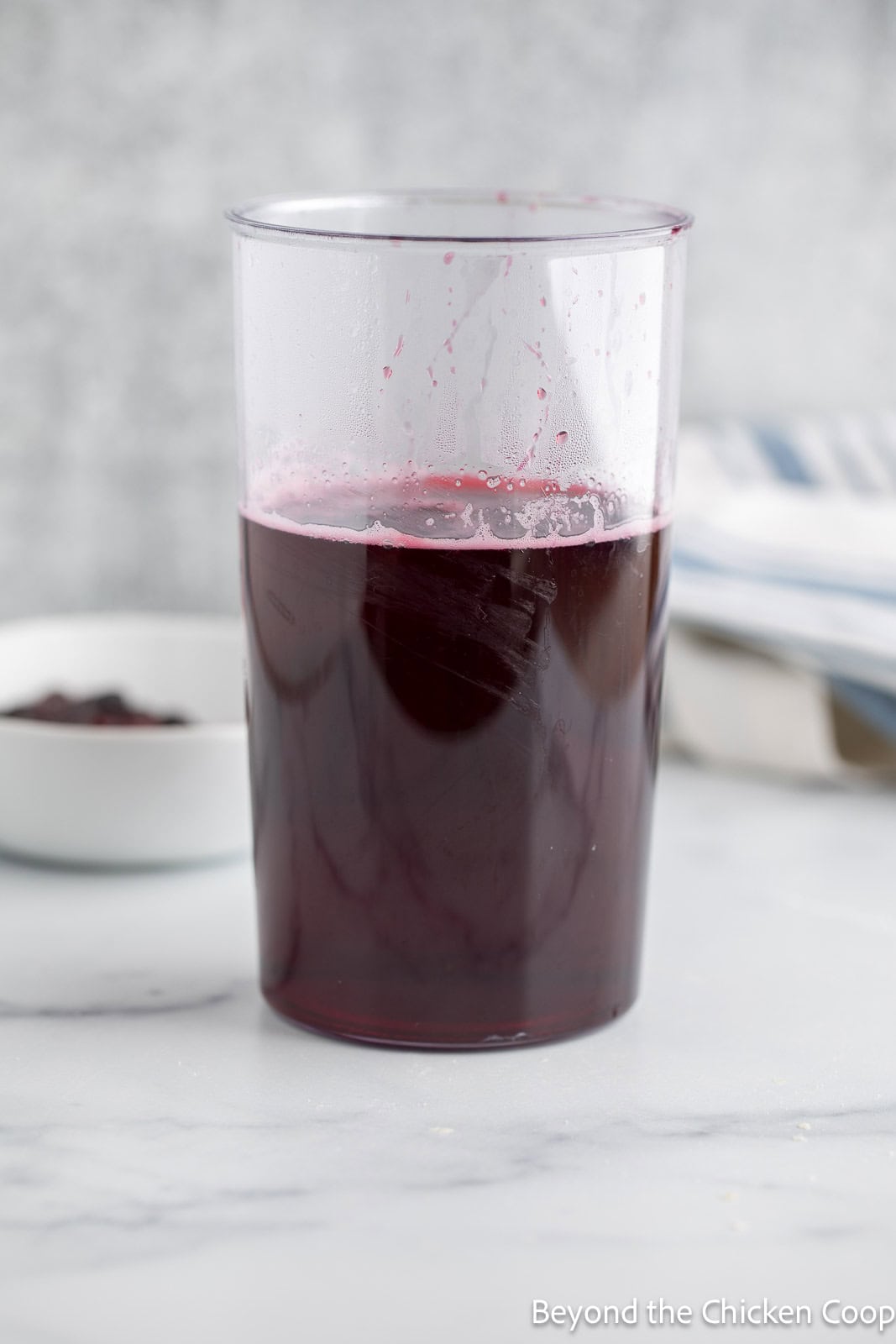 Huckleberry simple syrup in a tall plastic container. 