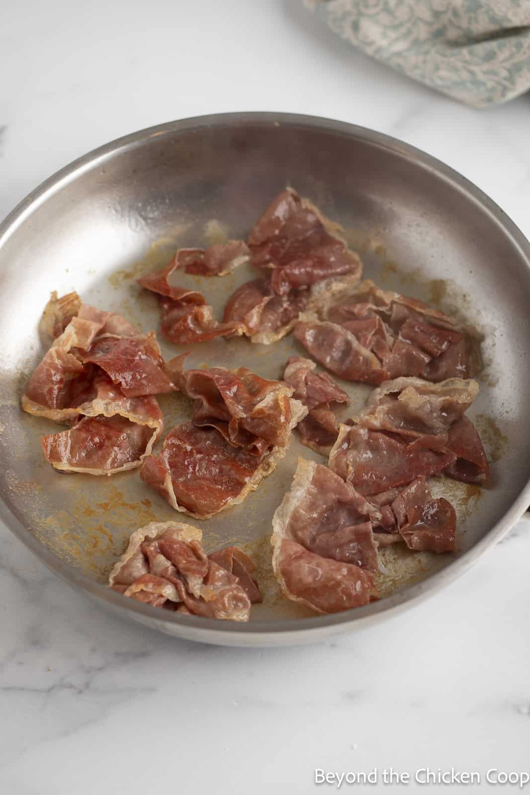 Cooking prosciutto in a skillet. 