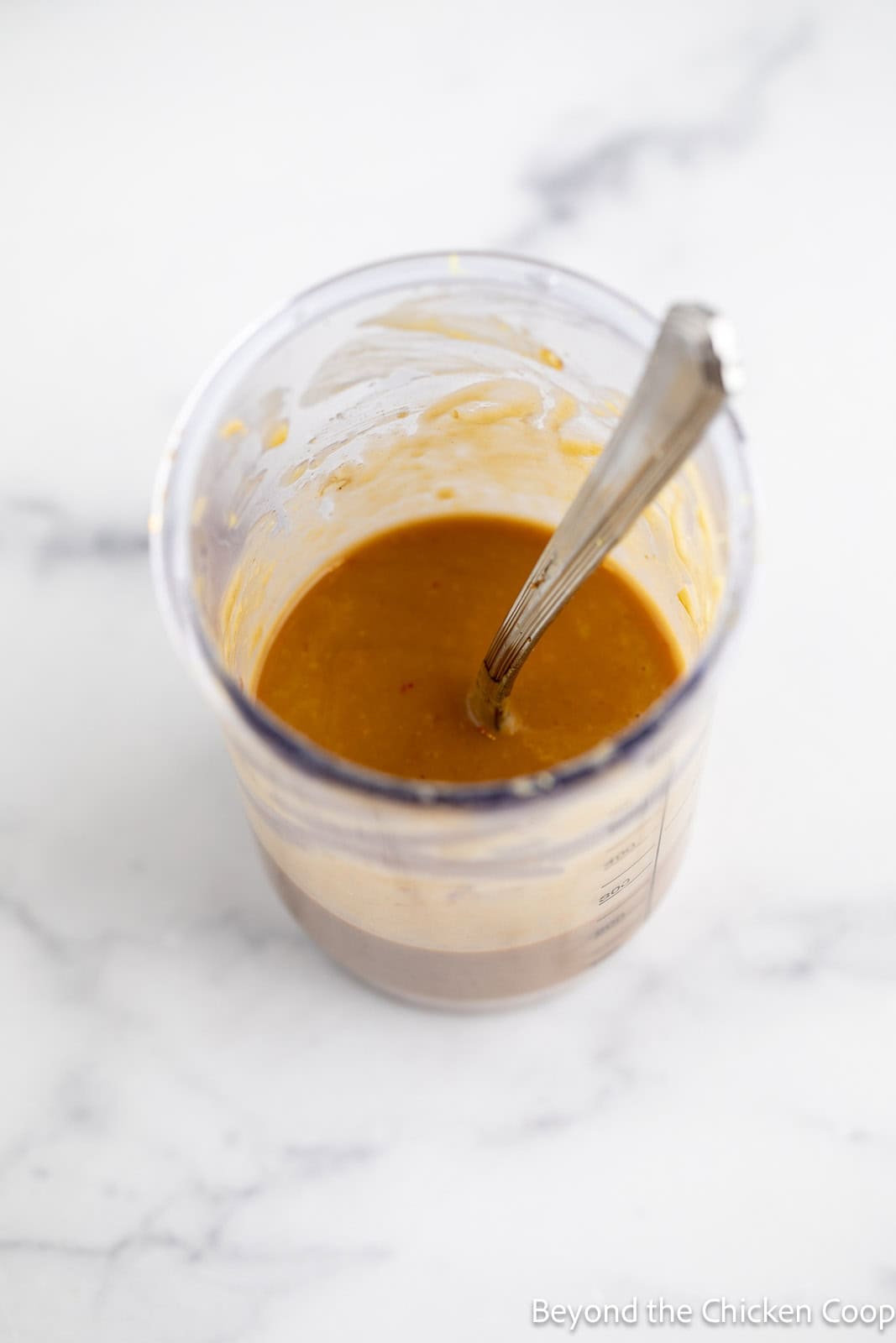 A creamy peanut sauce in a clear container. 
