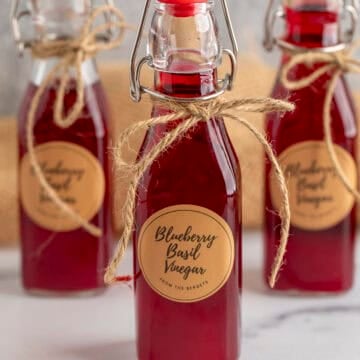 Jars of Blueberry Basil Vinegar tied with string.