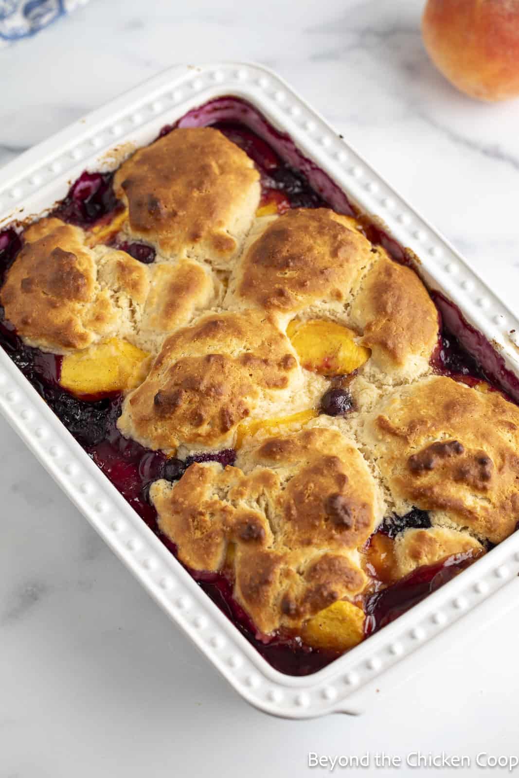 A baked peach cobbler with blueberries. 