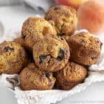 A basket filled with blueberry peach muffins.