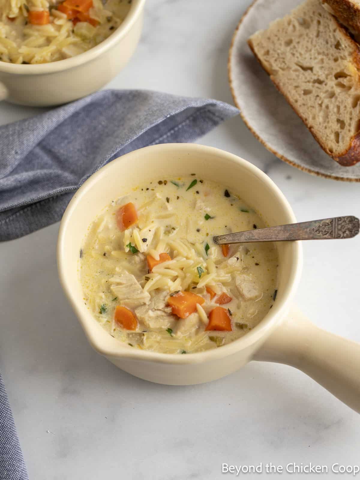Chicken soup in a bowl with a spoon.