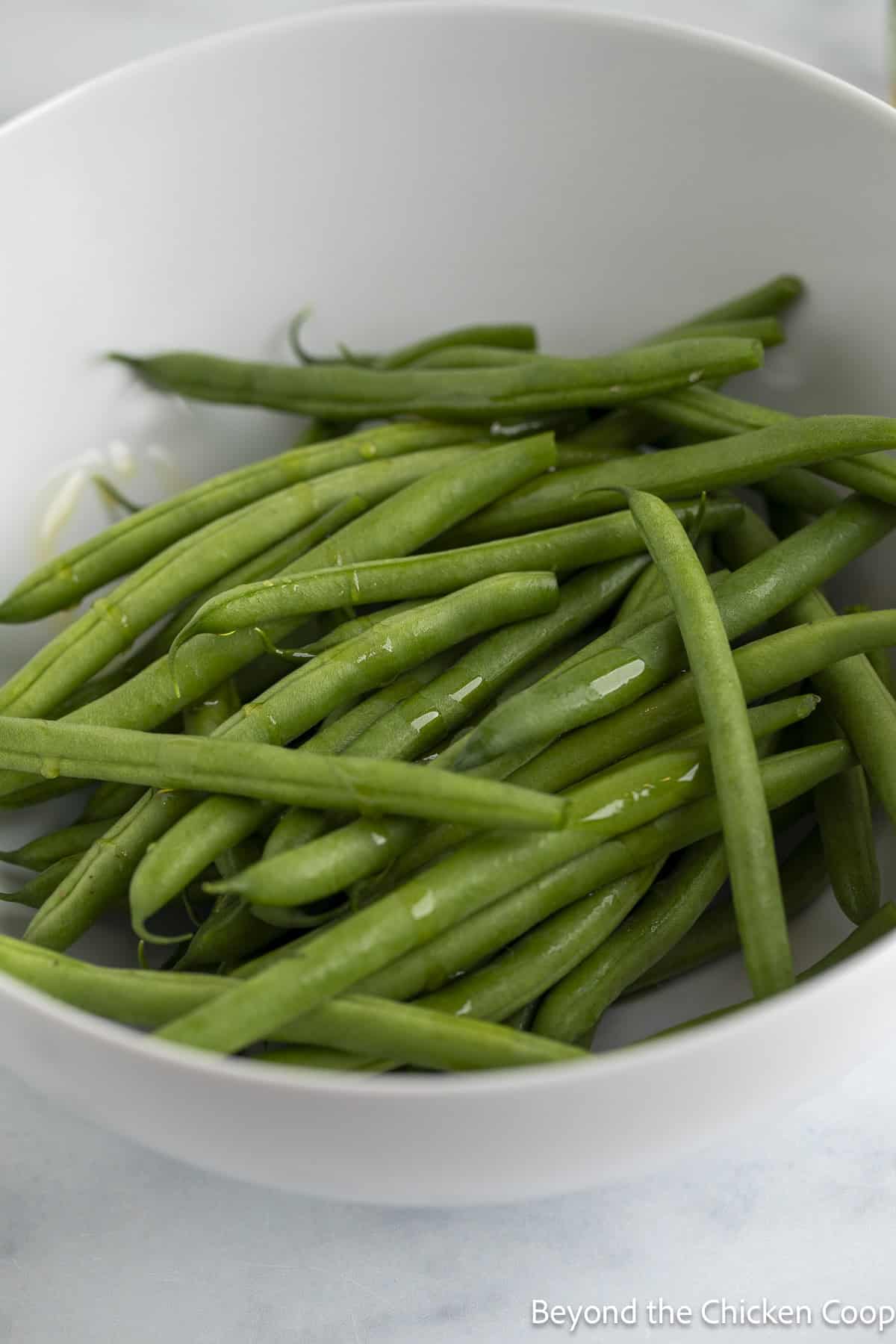 Fresh green beans in a white bowl. 