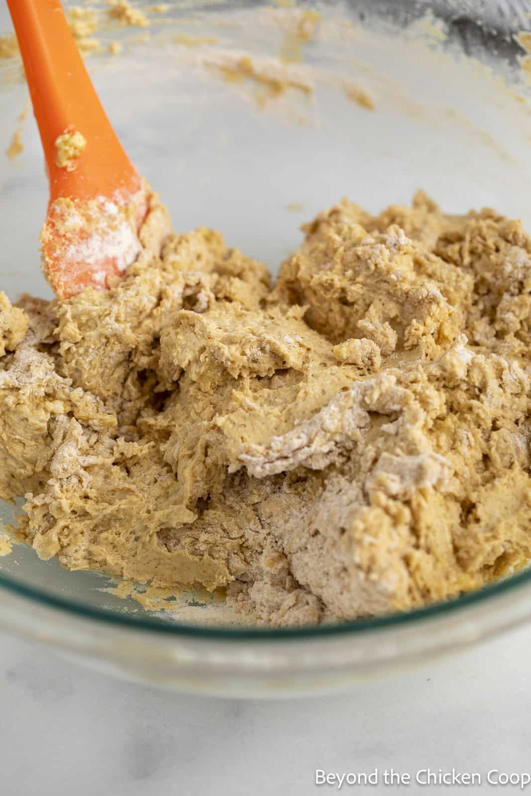 Mixing muffin batter in a bowl with a spatula.