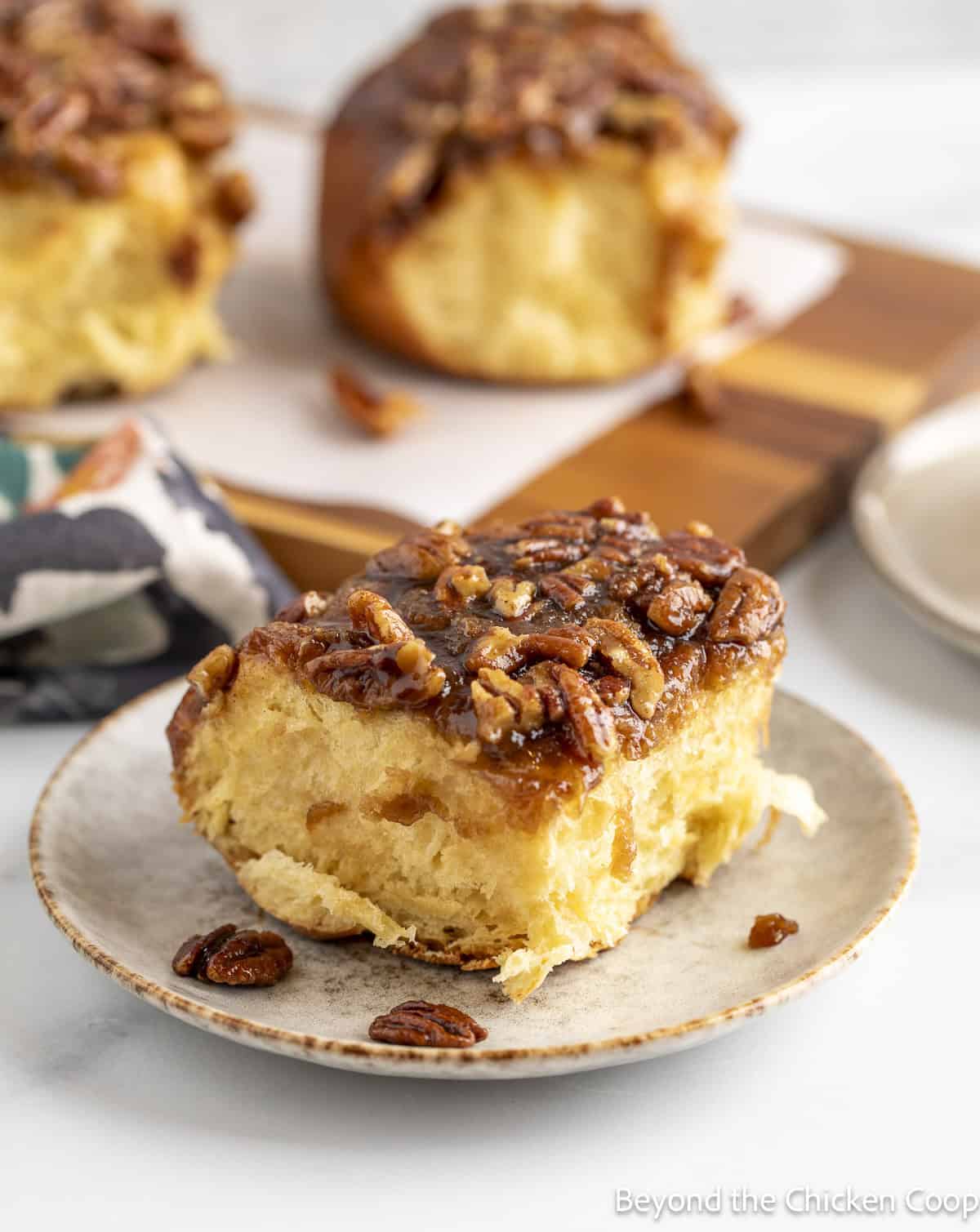 Sticky sweet roll with pecans on a plate. 
