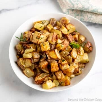 Roasted Yukon potatoes in a white bowl.
