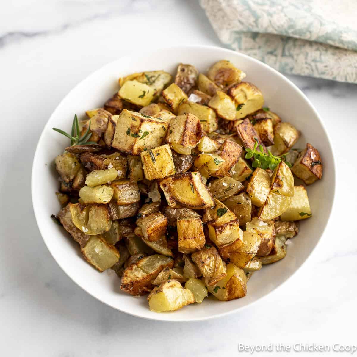 Roasted Yukon potatoes in a white bowl.
