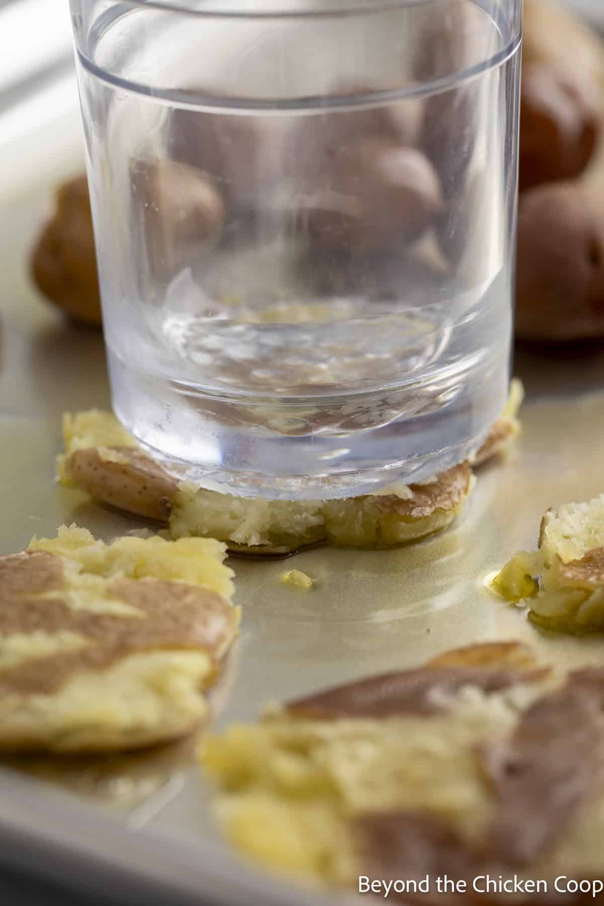 Smashing potatoes with the bottom of a glass.