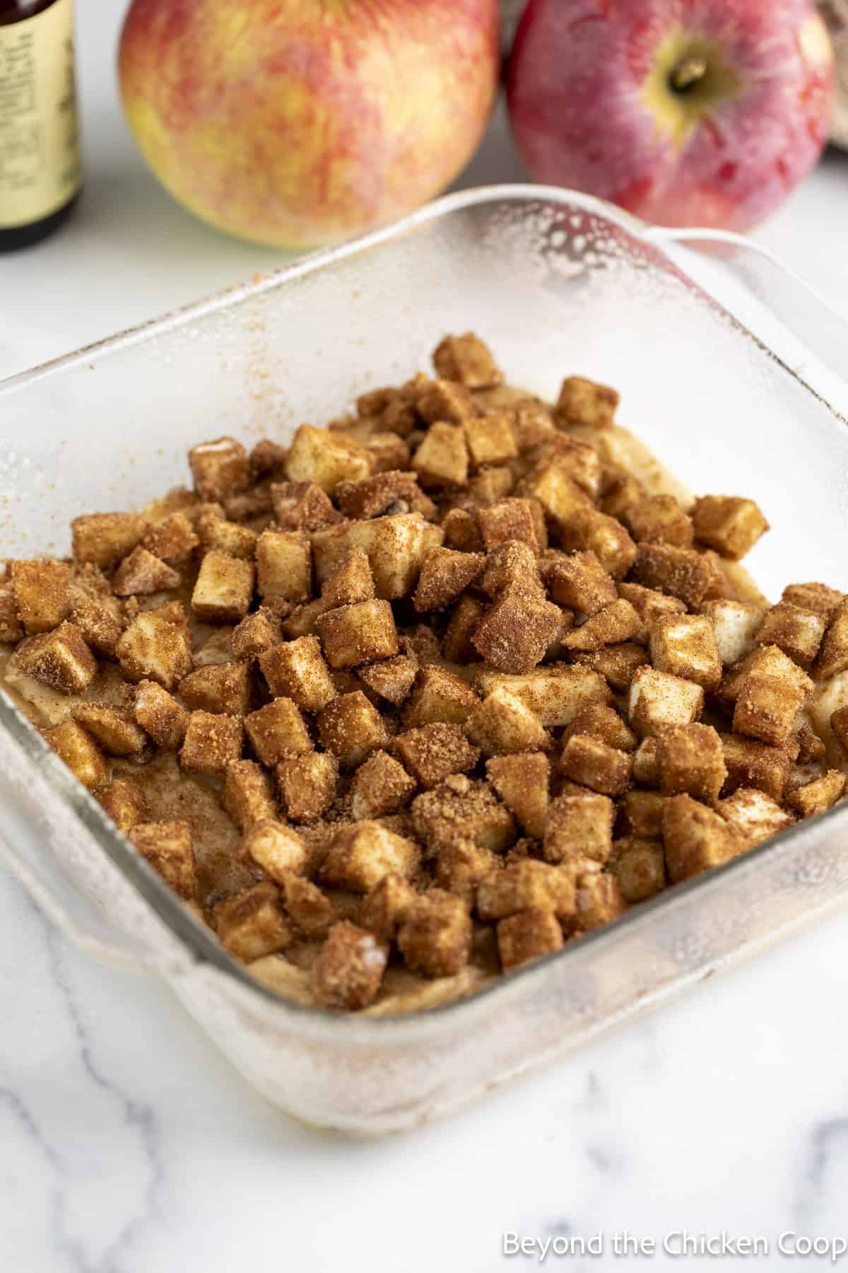 Diced apples on top of cake batter in a baking dish. 