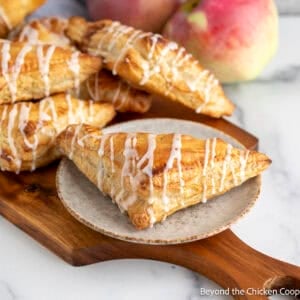 Apple Turnovers on a plate and on a wooden board.