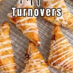 Apple turnovers drizzled with glaze on a baking rack.