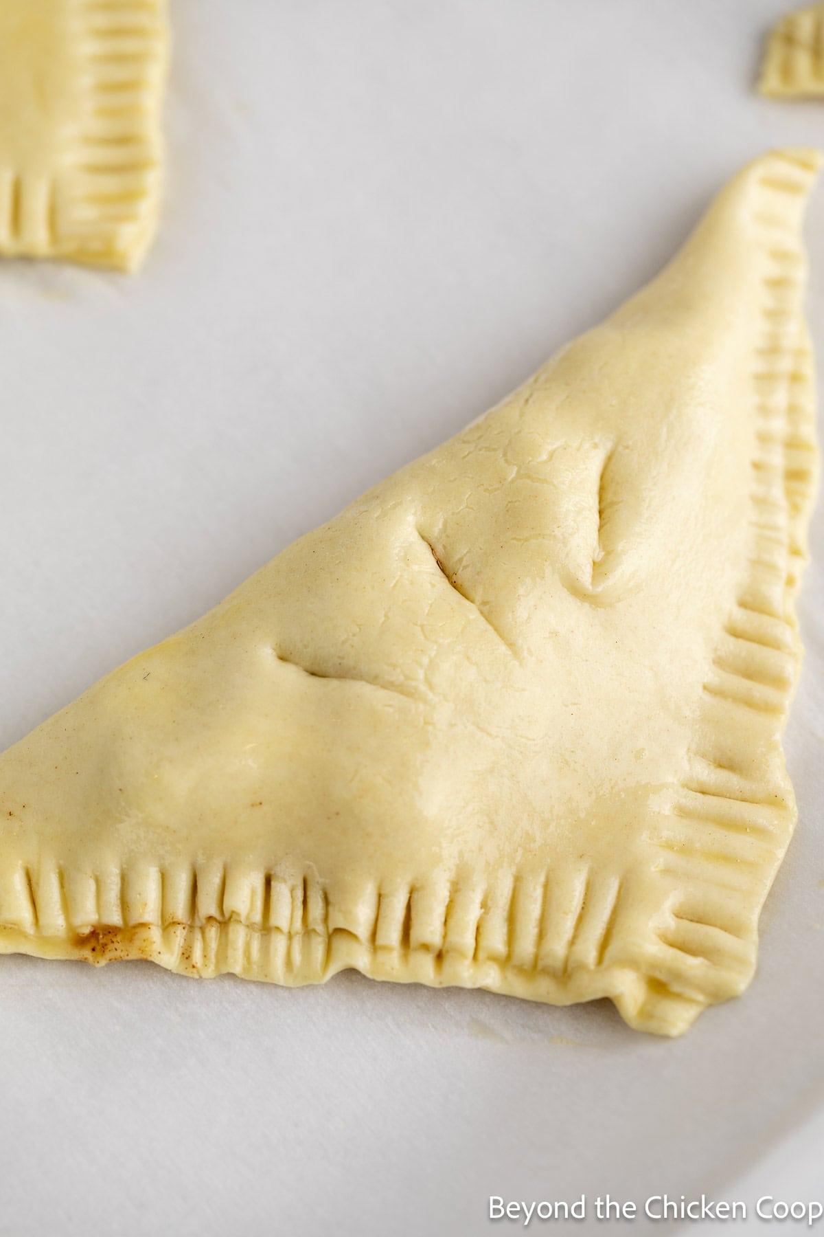 Three slits in the top of an unbaked turnover.