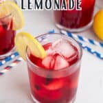 A glass of berry lemonade with lemon slices