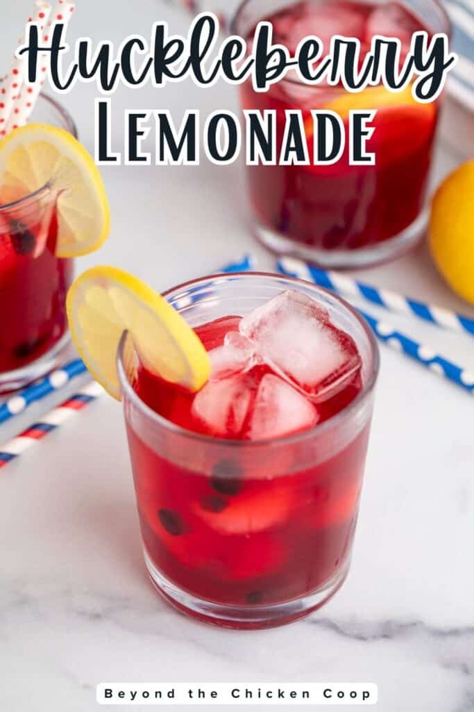 A glass of berry lemonade with lemon slices