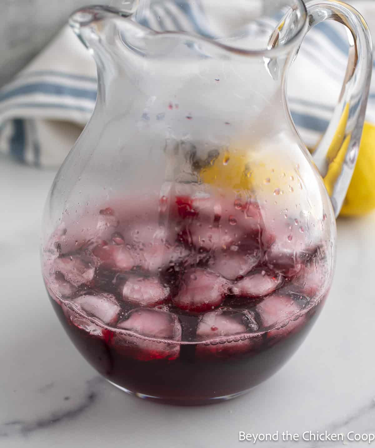 Huckleberry syrup in a glass pitcher with ice. 