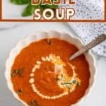 A bowl of tomato soup topped with fresh herbs and a drizzle of cream.