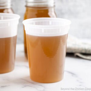 Homemade vegetable stock in a storage containers.