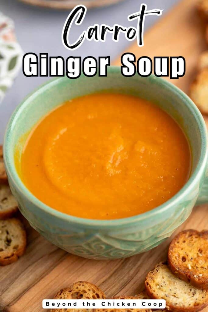 A green mug filled with carrot soup.