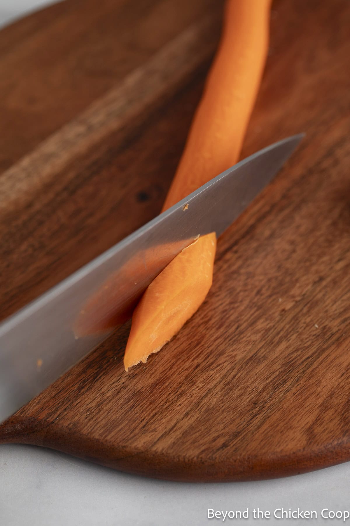Cutting carrots on a wooden cutting board.