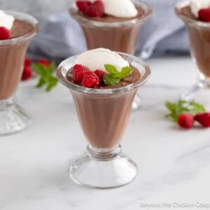 A glass parfait filled with chocolate pudding and whipped cream.