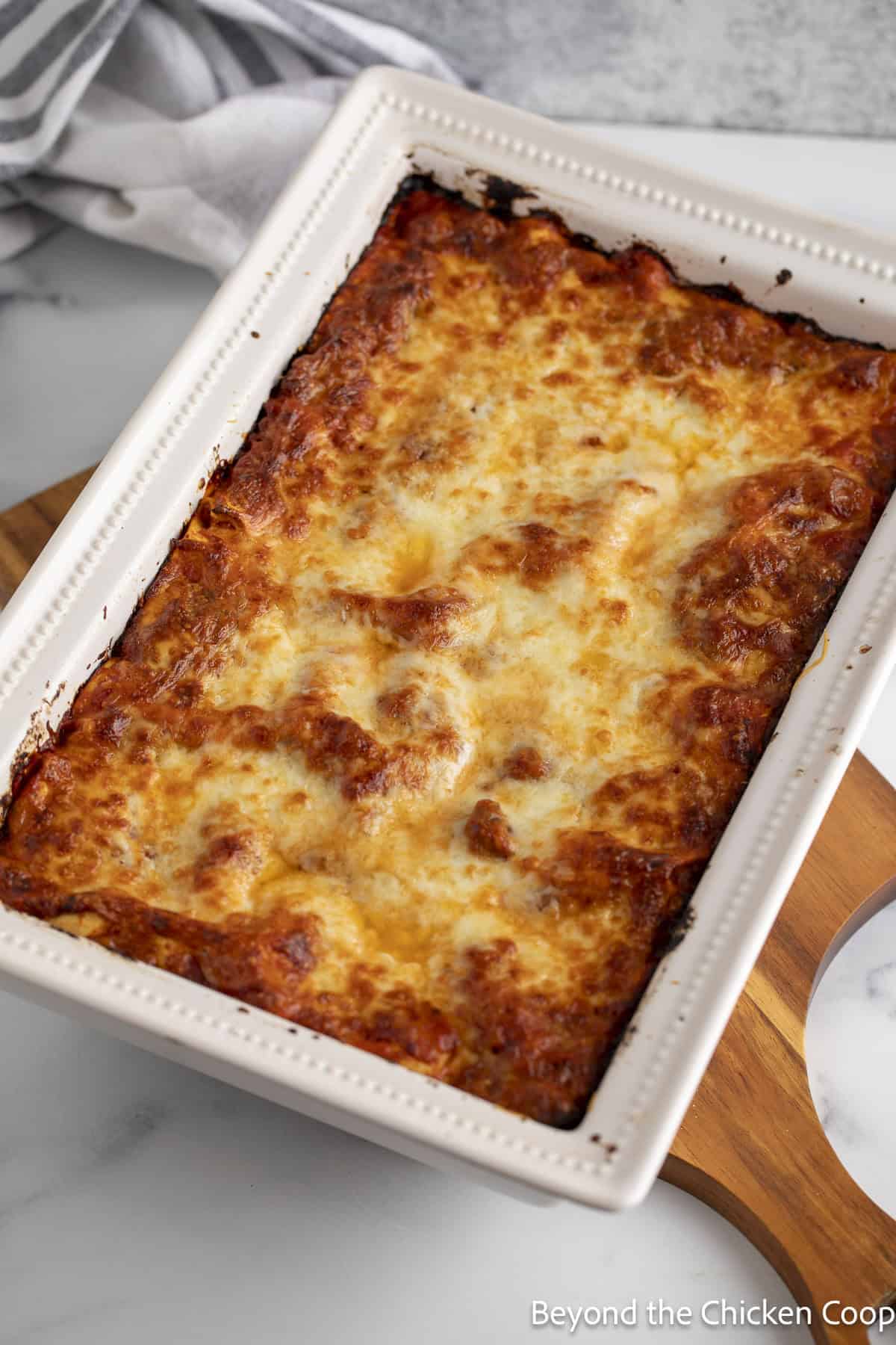 A baked lasagna in a white casserole dish. 