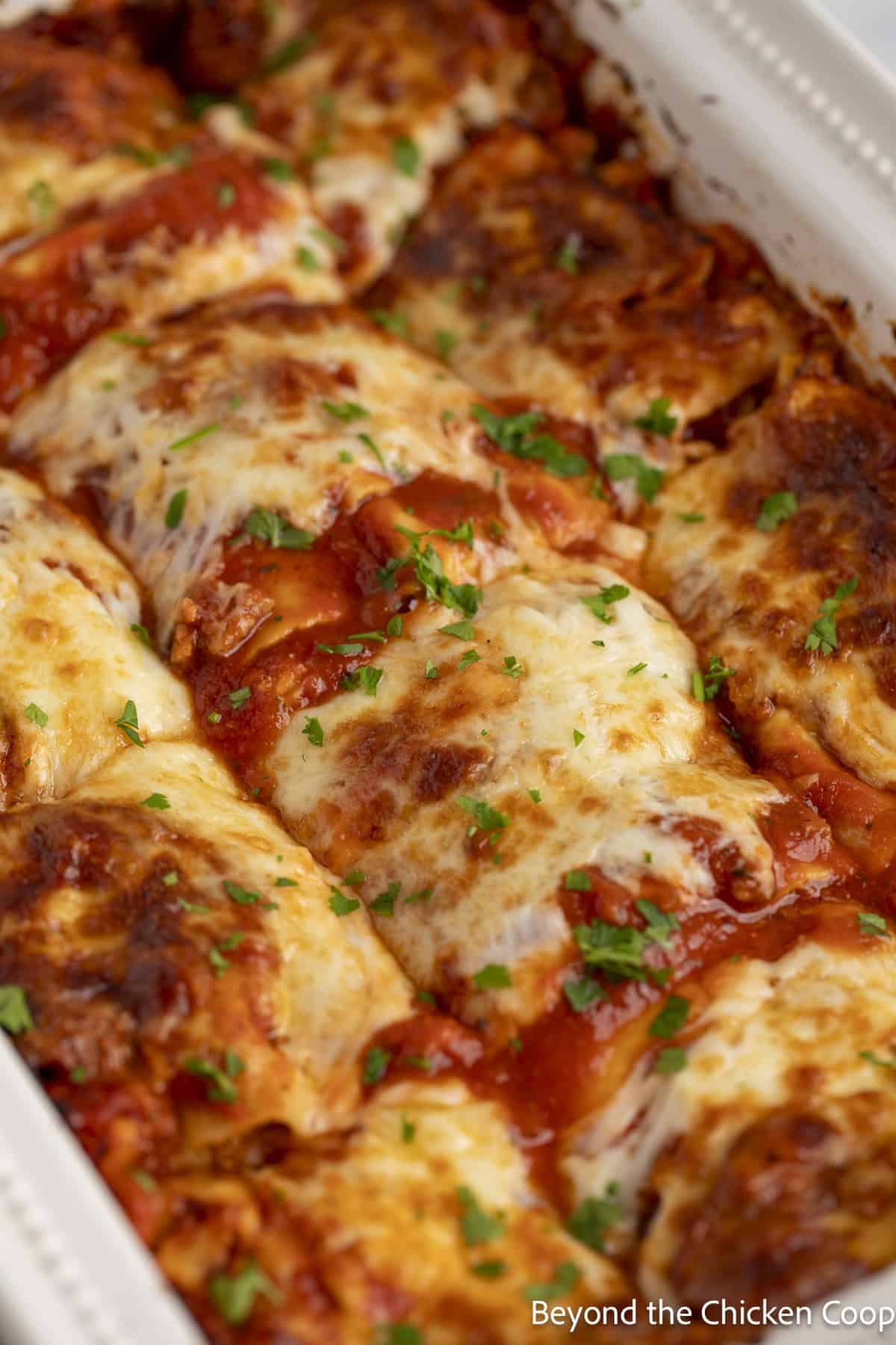 Sliced lasagna in a white casserole dish. 