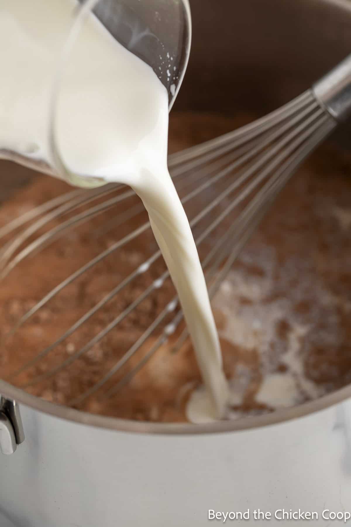Pouring milk into a saucepan. 