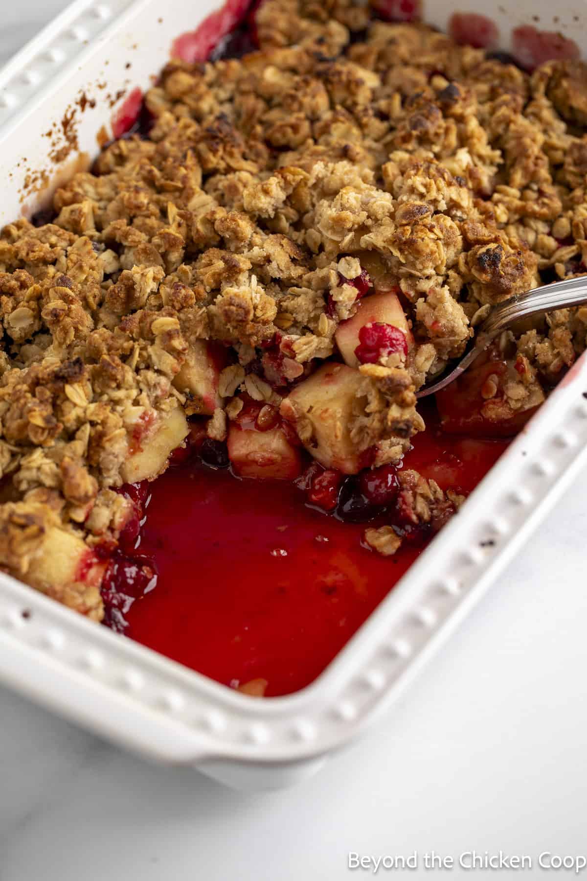 Cran apple oatmeal crisp in a white casserole dish.