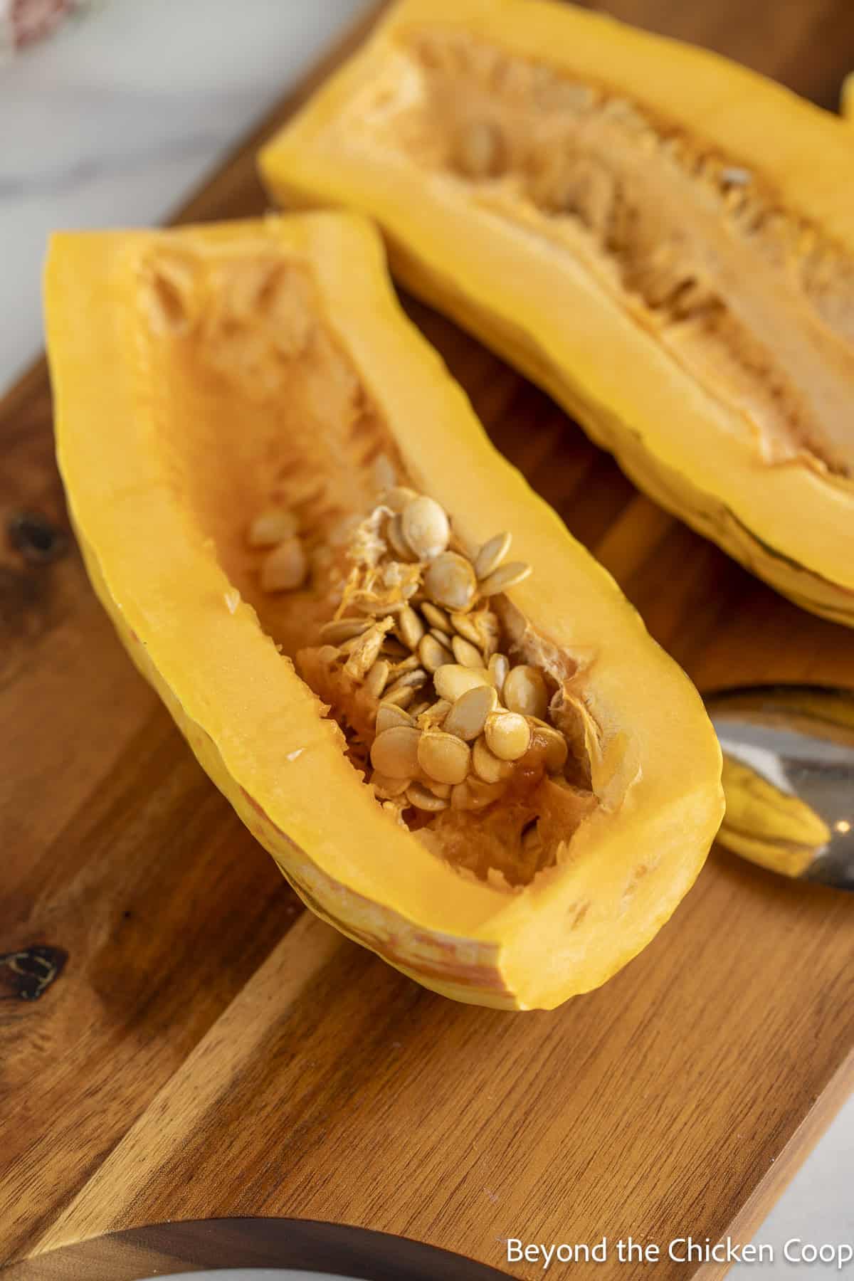 A sliced delicata squash with the seeds in the center.