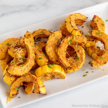 Roasted Delicata Squash on a white platter.