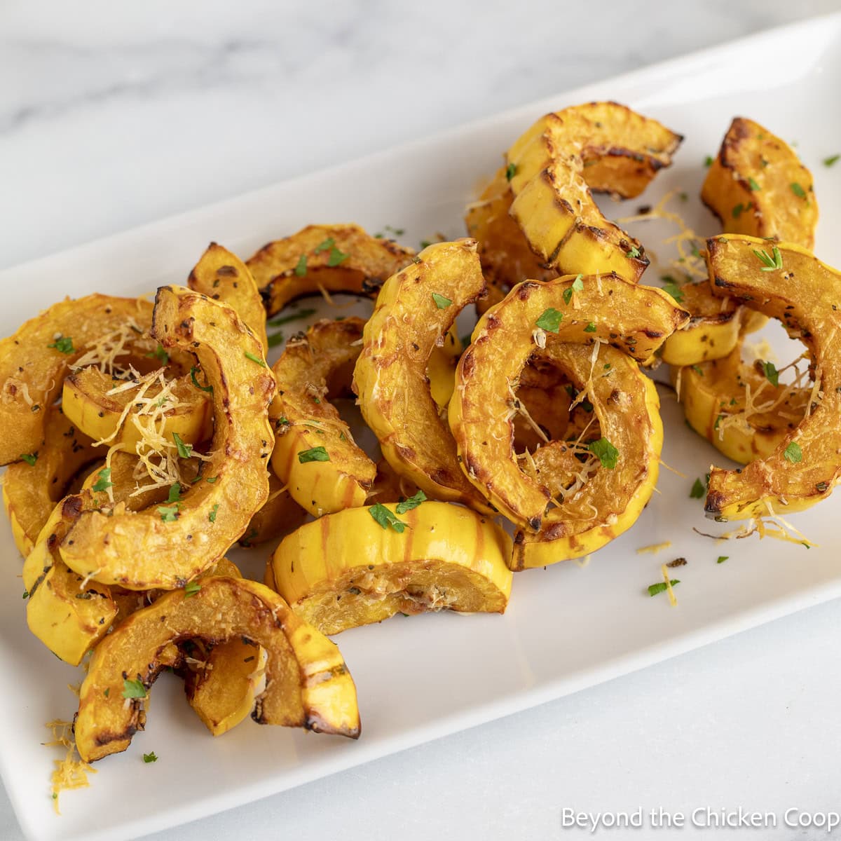 Roasted Delicata Squash on a white platter.