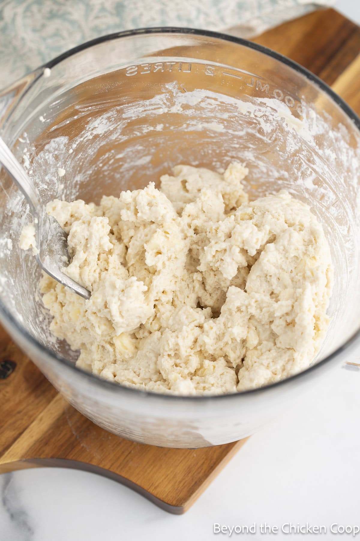 Biscuit dough in a glass mixing bowl.