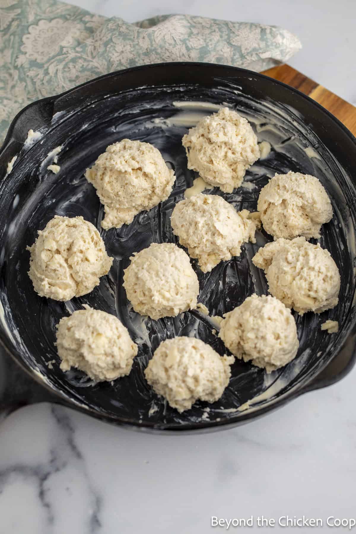 Drop biscuit dough in a cast iron skillet.