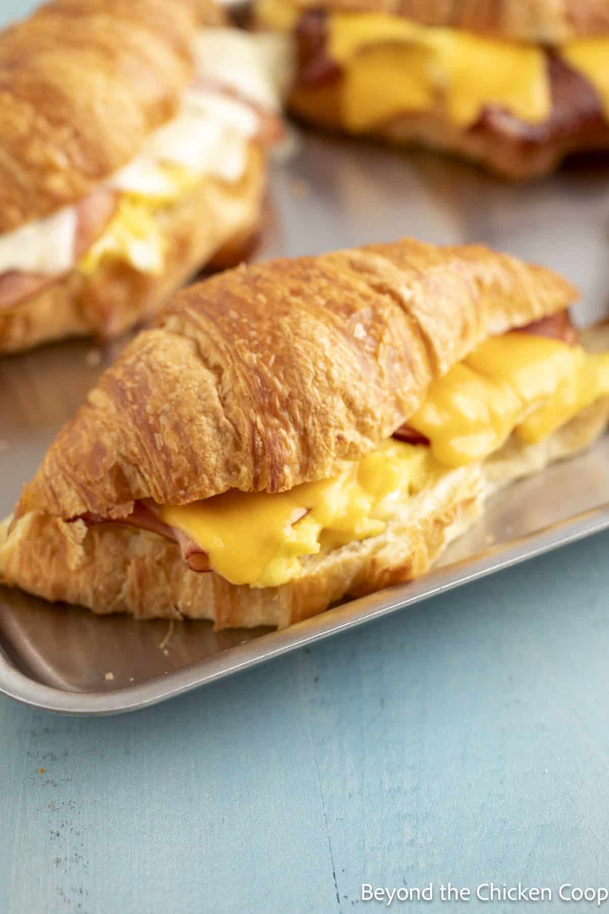 Melted cheese on a croissant sandwich.