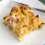 A slice of Croissant Breakfast Casserole on a white plate.